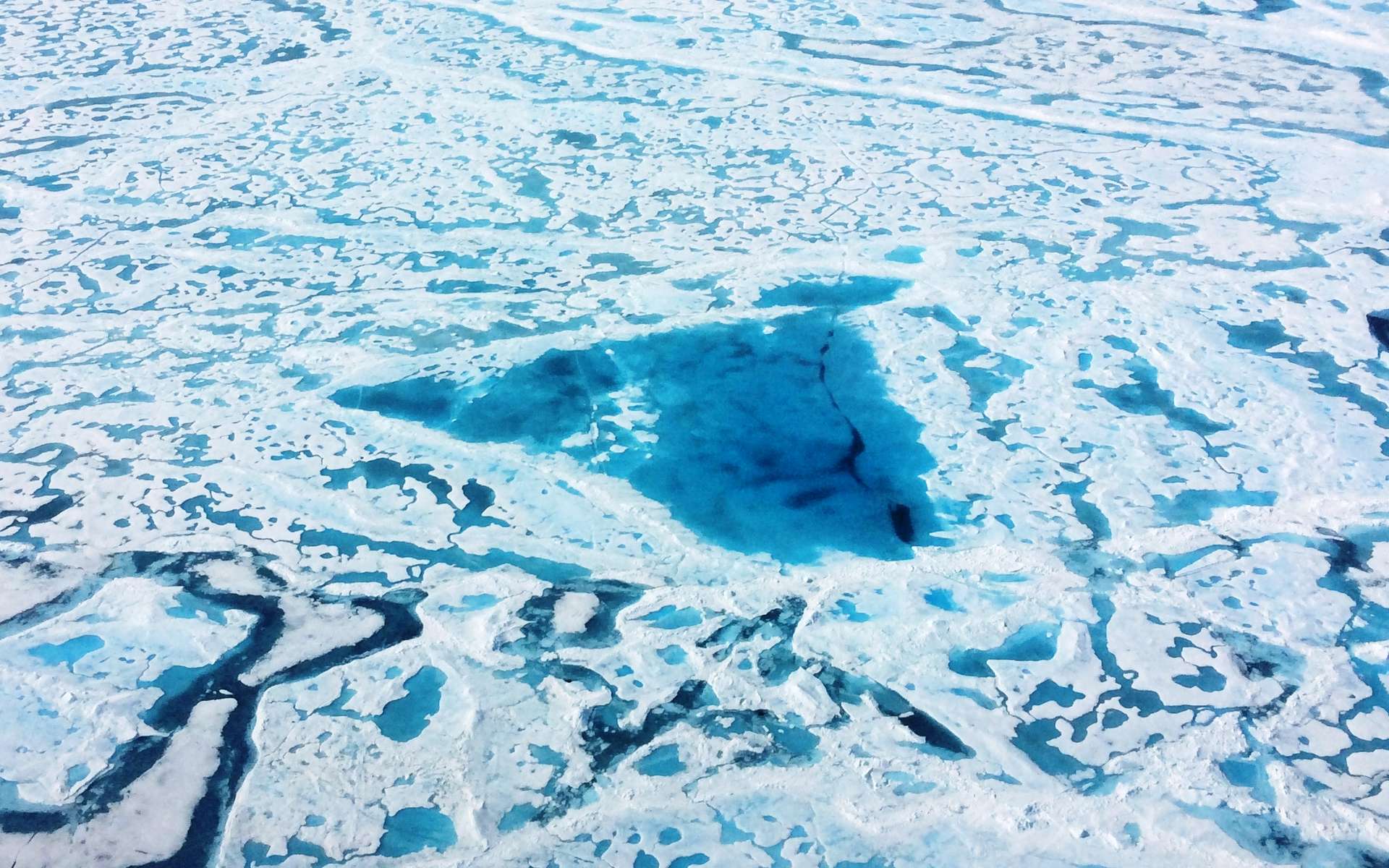 Cette image magnifique cache une réalité inquiétante : elle a été prise par avion lors d'une campagne pour évaluer l'importance de la fonte de la banquise arctique. Les zones bleues sont des régions où la banquise a partiellement fondu en surface. © Nasa, opération IceBridge