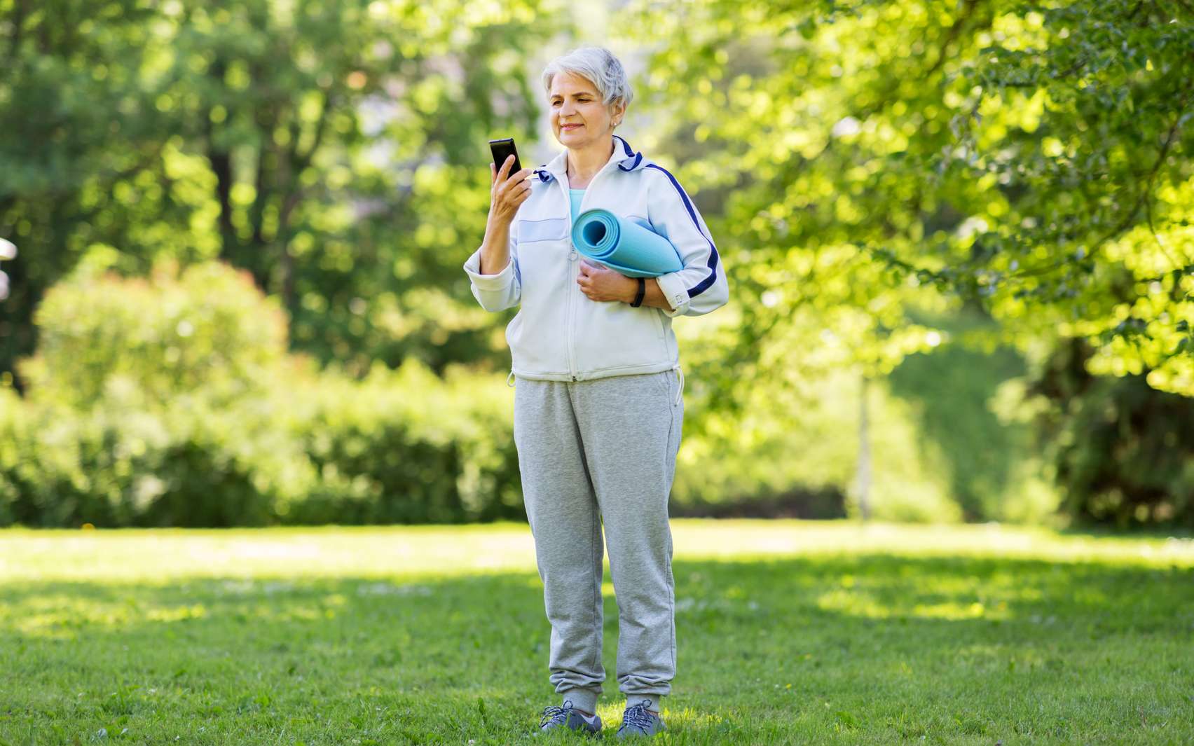 Une dame âgée pratiquant une activité physique à l'aide de son téléphone. © Syda productions, Fotolia