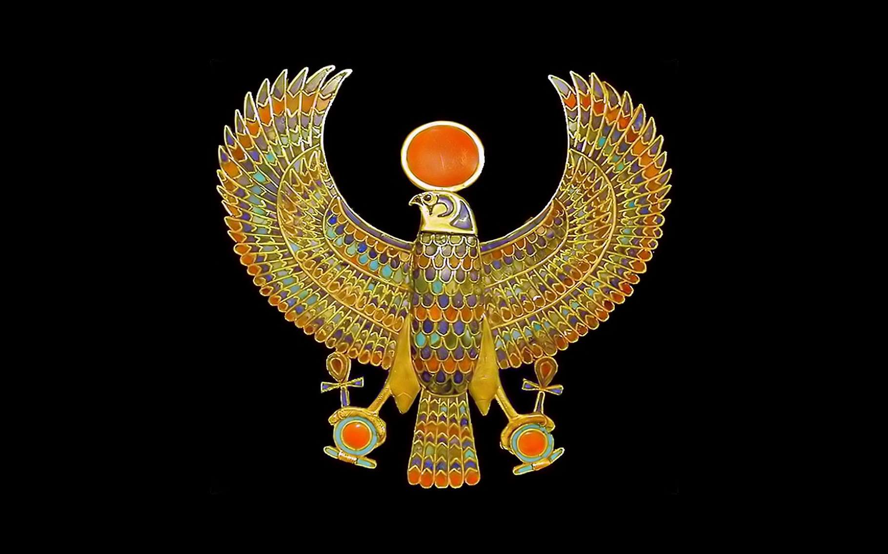 Le pectoral du pharaon, l'un des joyaux retrouvés au plus près de la momie. Ce bijou est un ornement vestimentaire ou corporel, orné de pierres semi-précieuses, turquoise, cornaline, lapis-lazuli, et de pâte de verre multicolore. Comme son nom l’indique, ce bijou pectoral se place sur le thorax, considéré chez les civilisations anciennes comme le siège de l’âme. Porté à cet endroit, il est supposé assurer une protection magique ou divine. Le faucon représente le dieu Horus, portant le disque solaire et déployant ses ailes en signe de souveraineté. Dans ses griffes, des attributs des dieux égyptiens, la croix Ânkh, signe de vie, et l’anneau Shen, signe d’éternité. Ce pectoral fait partie de 143 bijoux retrouvés, enfouis dans les bandelettes entourant la momie. © Jean-Pierre Dalbéra, Flickr, CC by 2.0