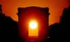 Illustration : Coucher de Soleil dans l'axe de l'Arc de Triomphe, à Paris, le 11 mai 2001. Objectif de 300 mm sur film 200 Asa Fujicolor. © Gilles Dawidowicz, Association pour la création et la diffusion scientifique