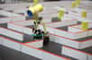 Connaissez-vous la Micromouse Robot Competition ? Elle se tient tous les ans au Japon et récompense de petits robots qui doivent retrouver le plus rapidement possible leur chemin dans un labyrinthe composé de cases.