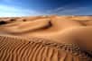 Le principe de la relation entre le nombre d'onde et la longueur d'onde peut-être utilisé pour étudier les ondulations sur les dunes du désert, et la façon dont elles se forment et évoluent sous l'action du vent. En mesurant la longueur d'onde et l'amplitude de ces ondes stationnaires, on peut prévoir les mouvements de sable dans le désert et protéger les infrastructures et les habitations contre les effets des dunes. © khorixas, Adobe Stock