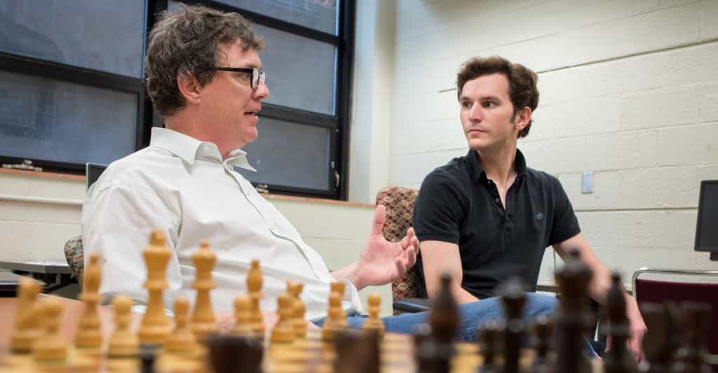 Zach Hambrick, à gauche, discute avec le jeune chercheur Alexander Burgoyne devant un plateau d'échecs. Pour eux, le talent à ce jeu ne peut pas venir seulement de l'entraînement. Il faut être intelligent. © G.L. Kohuth, Michigan State University