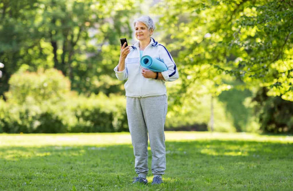 Une dame âgée pratiquant une activité physique à l'aide de son téléphone. © Syda productions, Fotolia