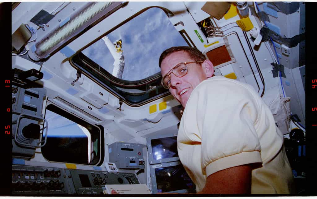 William S. McArthur aux commandes d'un bras robotique au cours de la mission STS-74 à bord de la navette Atlantis en novembre 1995. © Nasa