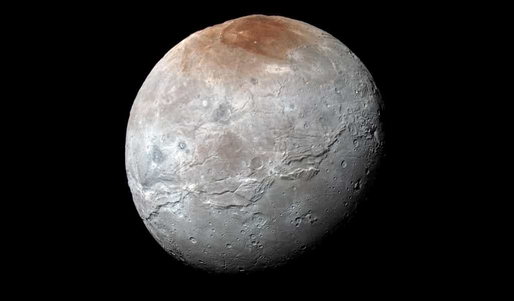 La sonde New Horizons a survolé Charon, la plus grosse lune de Pluton, en 2015 et en a dévoilé le visage balafré et cratérisé, surmonté d’un pôle nord aux teintes rougeâtres. © Nasa/JHUAPL/SwRI