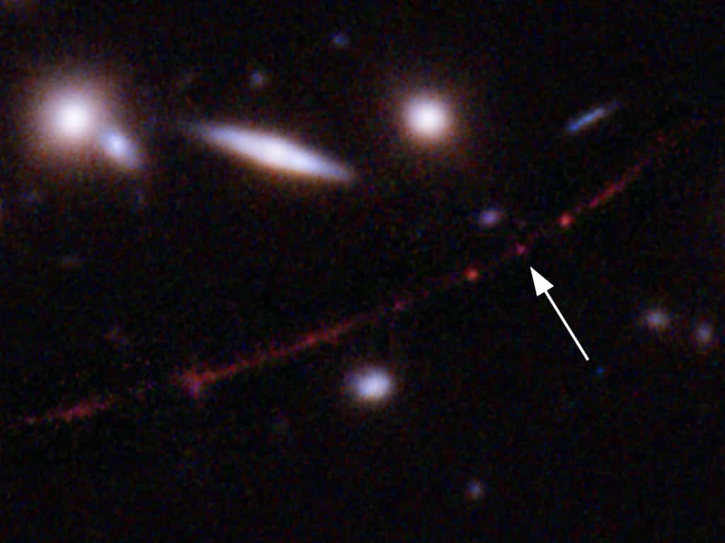 La flèche indique la localisation de l'étoile Earendel mais il s'agit ici d'une image prise avec Hubble. © Sciences : Nasa, ESA, Brian Welch (JHU), Dan Coe (STScI),&nbsp;traitement de l'image : Nasa, ESA, Alyssa Pagan (STScI)