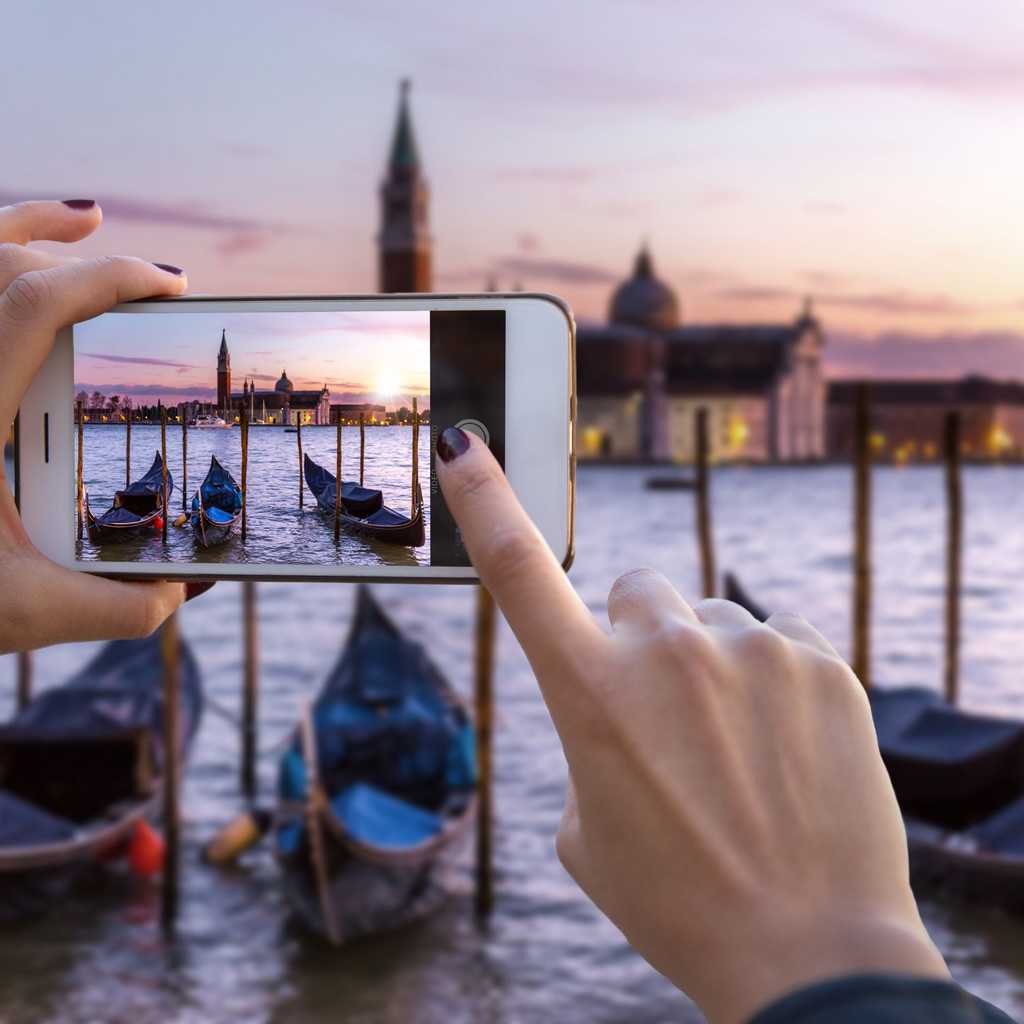 Personne en train de prendre en photo un paysage avec son smartphone © Shutterstock