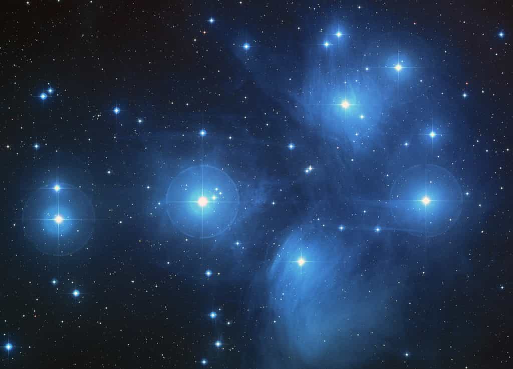 Les Pléiades, un amas ouvert d’environ 3000 étoiles et situé à une distance d'environ 440 années-lumière  de la Terre dans la constellation du Taureau photographiées ici avec Hubble. Ces étoiles sont jeunes et actuellement, l'amas est plongé dans un nuage de gaz et de poussières. © Nasa, DP