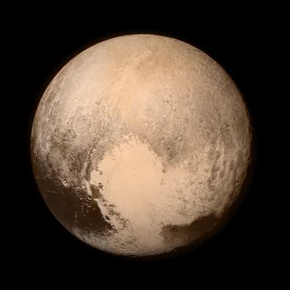 Le cœur de Pluton... Vue composite réalisée avec une image du télescope Lorri (pour les détails) et une autre fournie par l'instrument Ralph/MVIC (pour les couleurs), prises le 13 juillet 2015, à 768.000 km. On note cette surface claire, faite de glaces (azote, méthane, monoxyde de carbone...). C'est elle que New Horizons aura survolé ce 14 juillet 2015. On distingue aussi une région sombre, à gauche, appelée « la baleine ». Ce que l'on peut déjà retenir de cette image, c'est la complexité de la géologie de Pluton, avec son relief, ses glaces et ses roches. Mais aussi sa très probable activité météorologique, même si son atmosphère est très peu dense, avec des glaces qui se condensent ou se subliment. Des traces d'impacts pourront aussi raconter un peu de son histoire. © Nasa / JHUAPL / SwRI