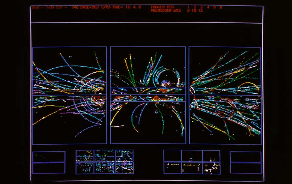 Les particules produites par des collisions de protons et d'antiprotons dans le détecteur UA1 au Cern en 1983 étaient étudiées avec des ordinateurs. On voit ici certaines des trajectoires de ces particules reproduites sur un écran par ces ordinateurs. © Cern