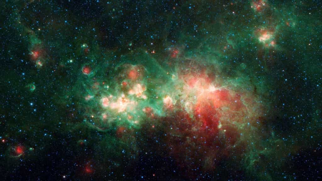 La nébuleuse de formation d'étoiles W51 est l'une des plus grandes « usines d'étoiles »&nbsp;de la Voie lactée. La poussière interstellaire bloque la lumière visible émise par cette région de la Galaxie mais pas dans le domaine de l'infrarouge ou des micro-ondes, ce qui permet d'étudier la cosmogonie stellaire. On voit ici en fausses couleurs une image de W51 prise par Spitzer. ©&nbsp;Nasa, JPL-Caltech