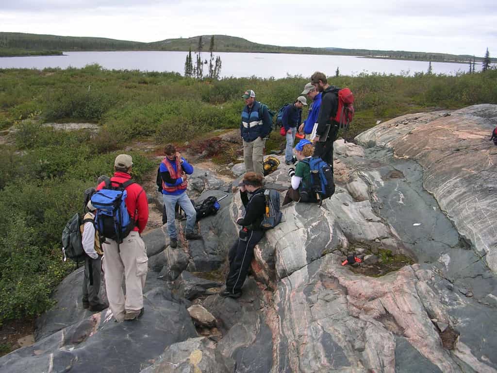 Une équipe d'étudiants en géologie examine l'affleurement rocheux de gneiss d'Acasta situé sur une île au Canada. Découvert en 1989, il tire son nom de sa proximité avec la rivière Acasta du Grand Lac de l'Ours. Ses roches ont des âges compris entre 4,03 à 3,58 milliards d'années et elles sont des vestiges de croûte continentale les plus anciens connus à ce jour. © Northwest Territories Geoscience Office