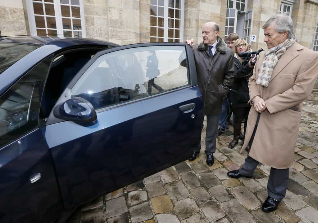 Alain Juppé, maire de Bordeaux, et Vincent Bolloré (de gauche à droite), devant une Bluecar électrique. L’industriel regarde déjà vers l’Asie pour y implanter son système d’autopartage en libre service. © Patrick Bernard, AFP Photo