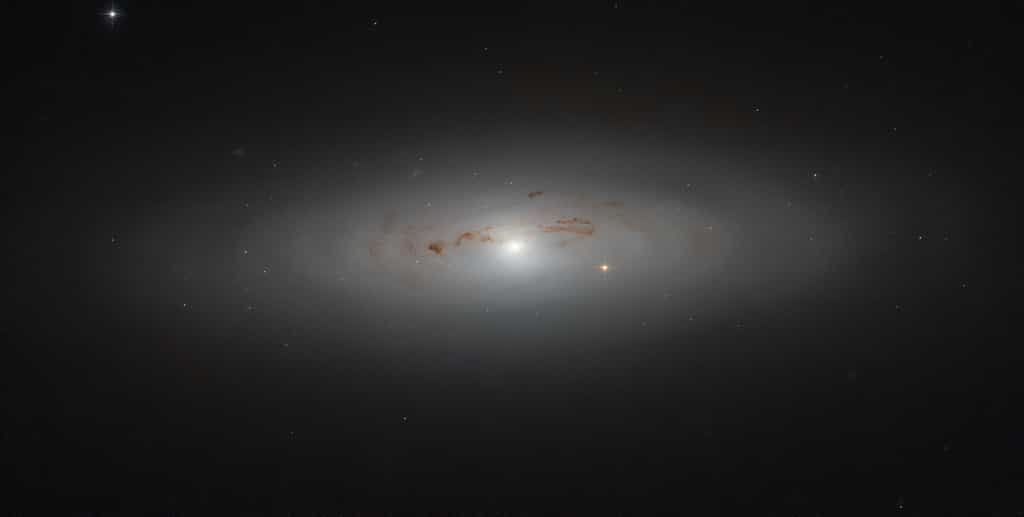 La galaxie NGC 4036, située à 70 millions d’années-lumière de la Terre, est enroulée dans un nuage de poussière et de gaz. ©  ESA/Hubble &amp; Nasa
