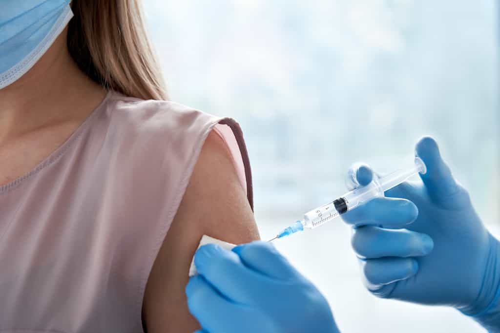 Une jeune femme se fait vacciner contre la Covid-19. © insta_photos, Adobe Stock
