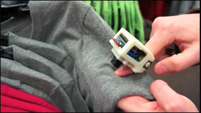 La bague EyeRing est ici pointée vers le T-shirt afin de détecter sa couleur. Pour cela, l’utilisateur presse le bouton latéral avec son pouce pour prendre une photo. Elle est transmise au smartphone (Android 2.2) par une connexion Bluetooth pour être analysée par l’application d’analyse d’image. Puis une application de reconnaissance va se charger de convertir la réponse sous forme vocale pour la transmettre via les écouteurs. © Suranga Nanayakkara/Roy Shilkrot/Patricia Maes/MIT Media Lab