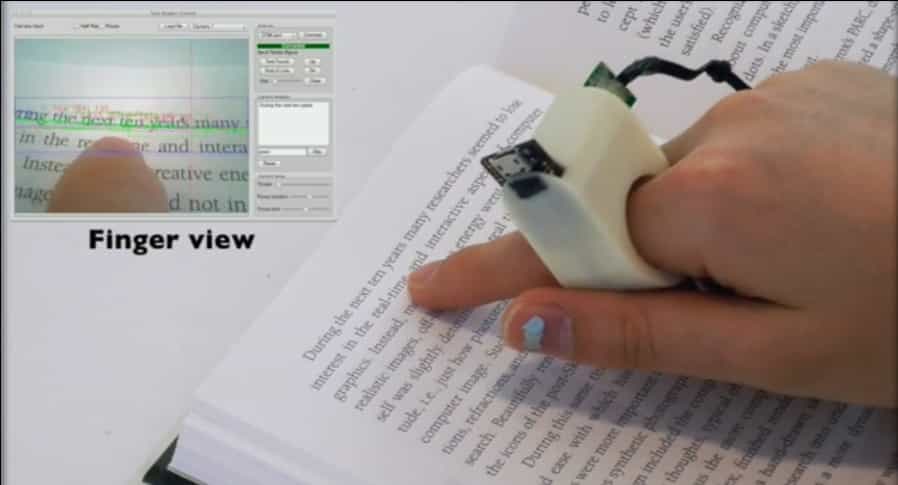 En août 2012, Futura-Sciences avait présenté la bague EyeRing mise au point par le Massachusetts Institute of Technology. Les chercheurs ont fait évoluer le concept pour le transformer en système de lecture pour les non-voyants. Rebaptisée FingerReader, la bague est équipée d’une microcaméra haute définition et d’un système de retour d’effets pour guider le doigt du lecteur. Le logiciel analyse le texte en temps réel et le restitue grâce à une voix de synthèse. © Media Lab, MIT