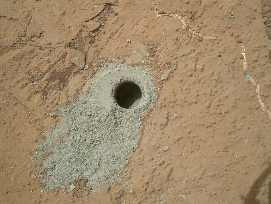 Le dernier forage effectué par Curiosity le 19 mai dernier (soit le sol 279) sur le rocher baptisé Cumberland, deuxième endroit ainsi étudié en profondeur après celui du mois de mars sur le rocher John Klein. On remarque la différence de couleur de la poussière sortie du trou de 1,6 cm (les couleurs sont celles de Mars, donc non corrigées), ce qui indique que le matériau enfoui a été protégé de l'oxydation. © Nasa, JPL-Caltech, MSSS