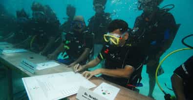 Aux Maldives, en 2009, le président Nasheed a réuni le conseil des ministres à quelques mètres de profondeur sous la surface de la mer et a signé un appel à lutter contre les émissions de CO2. © The President's Office, République des Maldives