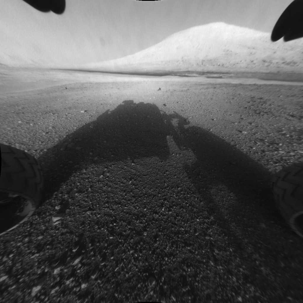 Sur cette image : l'ombre du rover Curiosity sur le sol martien&nbsp;et sa cible en face, le mont Sharp. ©&nbsp;Nasa/JPL-Caltech