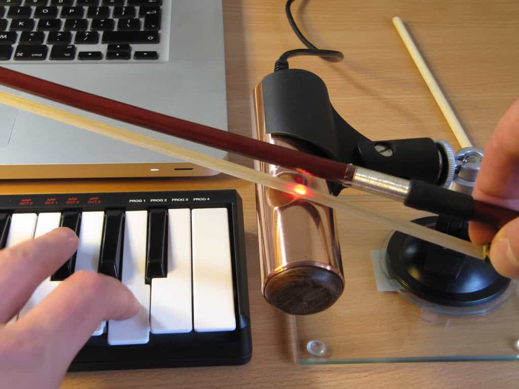 Le violon électronique O-Bow est fabriqué à partir d’un cylindre en cuivre qui comporte une zone incurvée en son centre, dans laquelle est logé un capteur optique comme celui qu’utilisent les souris informatiques. Il est relié à un ordinateur, et l’on se sert d’un clavier de piano électronique pour composer les notes tout en manœuvrant l’archet. © Université De Monfort, Dylan Menzies