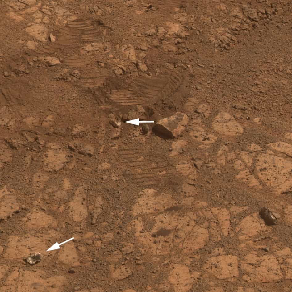 Une nouvelle image du caillou Pinnacle Island prise par la caméra panoramique (Pancam) d'Opportunity. La pierre mystérieuse est en bas à gauche, indiquée par une flèche. On remarque une roche à l'aspect semblable au niveau des traces de roues du rover qui a manœuvré à cet endroit. Sur Terre, Opportunity pèserait 174 kg, soit, sur Mars, l'équivalent de 66 kg. Le poids a suffi pour casser cette petite roche, riche en soufre et en manganèse. La signature de l'eau, dit la Nasa. © Nasa, JPL-Caltech, université Cornell, université d’État de l’Arizona