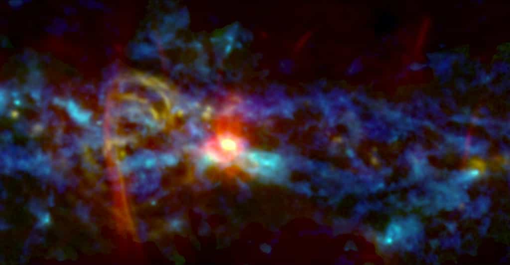 La zone centrale de notre galaxie abrite la plus grande et la plus dense collection de nuages moléculaires géants de la Voie lactée, matière première pour fabriquer des dizaines de millions d’étoiles. Cette image combine des observations d’archivage infrarouge (bleu), radio (rouge) et de nouvelles observations micro-ondes (vert) de l’instrument Gismo. Elle révèle, entre autres, des filaments de gaz ionisés faisant penser à un sucre d’orge et formés aux bords d’une bulle soufflée par un évènement puissant au centre de la galaxie. © Nasa's Goddard Space Flight Center