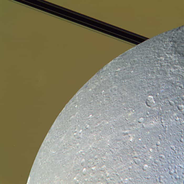 Image composite colorisée montrant la surface de Dioné alors que le satellite est en train de passer devant Saturne et ses anneaux. © Nasa/JPL/SSI/J. Major
