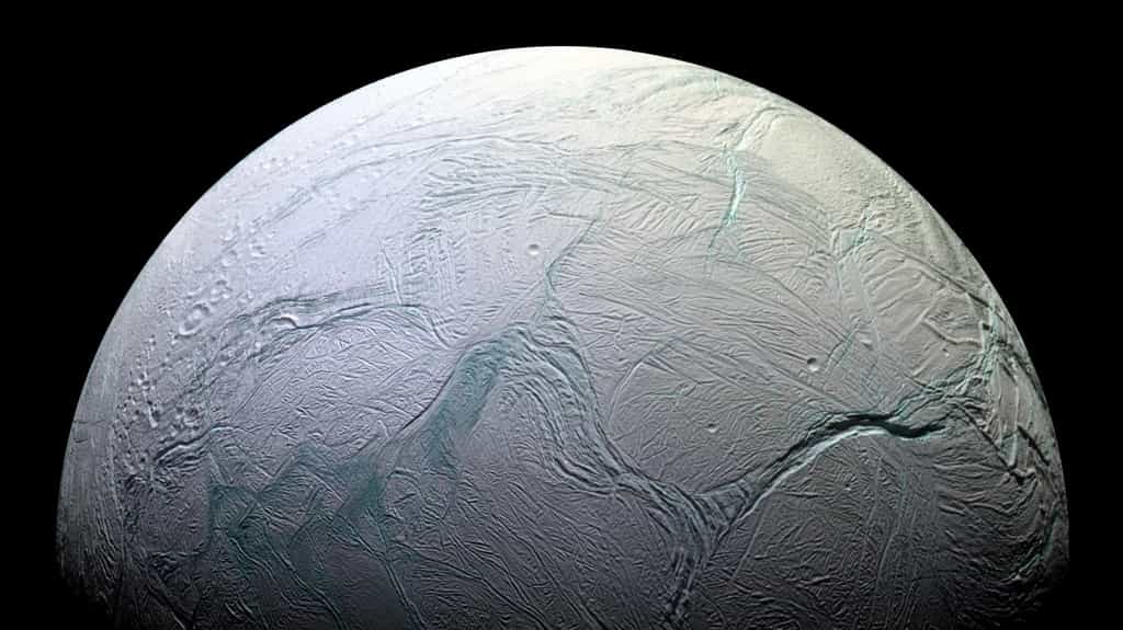 Encelade, un des satellites de Saturne, photographié par la sonde Cassini. Sa surface de glace cache des masses d'eau liquide. Dans ce monde froid, la chaleur vient du malaxage de cette lune par la gravité de la géante gazeuse. L'étude fine de ses mouvements permet de mieux comprendre à la fois Encelade et Saturne. © Nasa