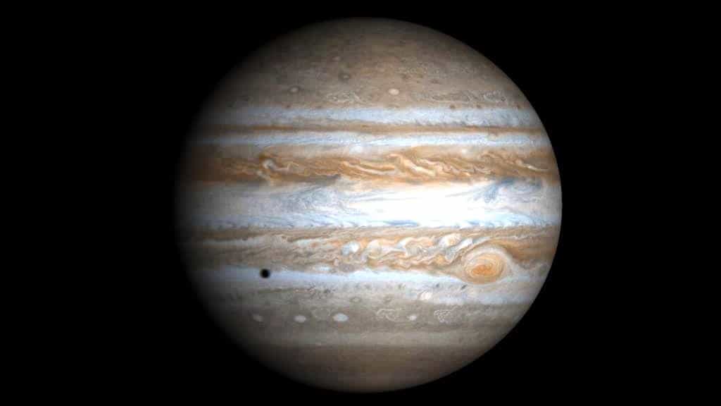 La planète Jupiter photographiée par la sonde Cassini. L'ombre portée sur la géante par l'une de ses lunes est visible en bas à gauche. © Nasa