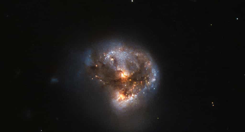 Sur cette image en fausses couleurs (la rouge correspond à l'infrarouge et les autres au visible), on voit la source infrarouge IRAS 16399-0937 observée par Hubble. Il s'agit de deux galaxies en cours de fusion après une collision. Elles sont le siège d'un mégamaser. © ESA, Hubble &amp; Nasa, Judy Schmidt