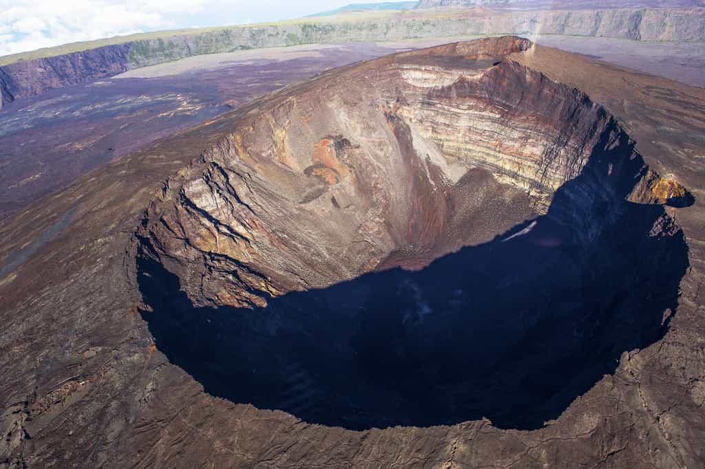 Le cratère Dolomieu, que l'on voit sur cette photo, est, avec le cratère Bory, l'un des deux cratères volcaniques situés au sommet du piton de la Fournaise, à La Réunion. Comme les volcans d'Hawaï, c'est un volcan de point chaud. Son activité est cependant moins intense que celle du Kīlauea mais on peut la comparer à celle de l'Etna, en Sicile. © photogolfer, Shutterstock