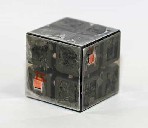 La partie centrale de la machine : Un cube incrusté de diamant enserré entre des feuilles de muscovite. Des contacts électriques en cuivre pour le chauffage sont également visibles. Crédit : Science.
