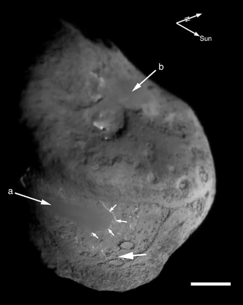 La sonde Deep Impact a prise cette image de la surface de la comète Tempel 1. On remarque des zones bizarrement lisses, peut-être des traçes de fusion récente de la surface de la comète (flèches a et b). En haut à droite les deux flèches indiquent la direction du Soleil et le nord de la comète. Crédit : Nasa/UM M. F. A'Hearn et al., Science 310, 258 (2005)