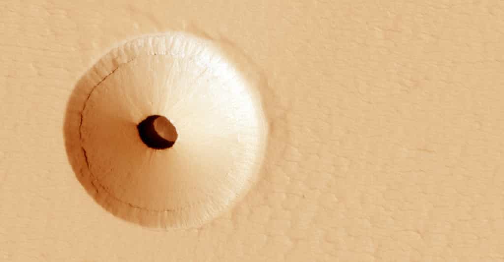 En 2011, Mars Reconnaissance Orbiter a découvert par hasard, sur le flanc d’un volcan martien, un mystérieux trou. Le témoin de l’activité volcanique passée de la région. © Université de l’Arizona, JPL, Nasa