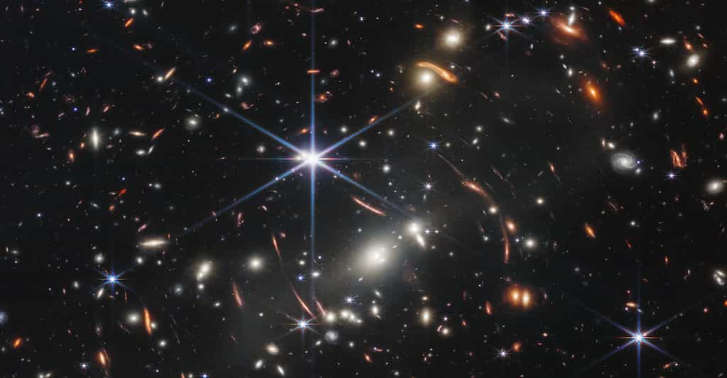 Sur ce « premier champ profond de Webb », apparaissent des objets compacts (vers le centre, en bas) que des astronomes viennent d’identifier comme les plus lointains amas globulaires jamais observés. © Nasa, ESA, CSA, STScl