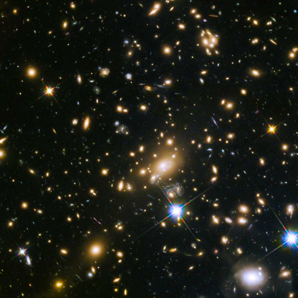 Cette image montre l'immense amas de galaxies MACS J1149.5+223, dont la lumière a mis plus de 5 milliards d'années pour nous parvenir. L'énorme masse de l'amas dévie la lumière d'objets plus éloignés. La lumière de ces objets a été amplifiée et déformée en raison de l'effet de lentille gravitationnelle. La galaxie MACS J1149.5+223 a pu être observée grâce à lui. © Nasa, ESA, S. Rodney (John Hopkins University, USA) and the FrontierSN team; T. Treu (University of California Los Angeles, USA), P. Kelly (University of California Berkeley, USA) and the GLASS team; J. Lotz (STScI) and the Frontier Fields team; M. Postman (STScI) and the CLASH team; and Z. Levay (STScI)