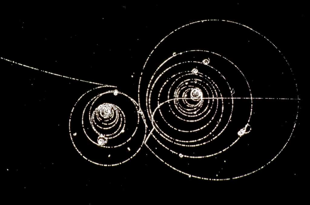 Des particules de matière et d'antimatière tournent en spirale dans un champ magnétique. C'est une image prise dans une chambre à bulles, un détecteur utilisé il y a plus de 50 ans. © Cern