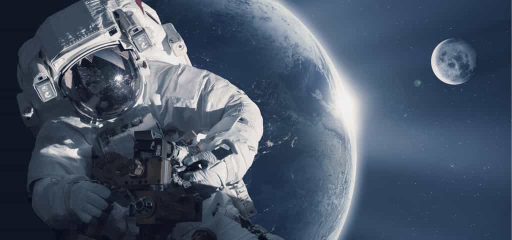 Illustration d'un astronaute dans l'espace, devant la Terre et la Lune. Au menu des discussions du 30e congrès mondial des astronautes : L'espace est mon futur. © santoelia, fotolia