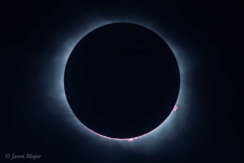 Le Soleil et la Lune au moment de la totalité en Caroline du Sud. Du disque noir ne dépassent que les protubérances solaires. Les deux astres alignés sont nimbés de la couronne solaire. © Jason Major, lightsinthedark.com