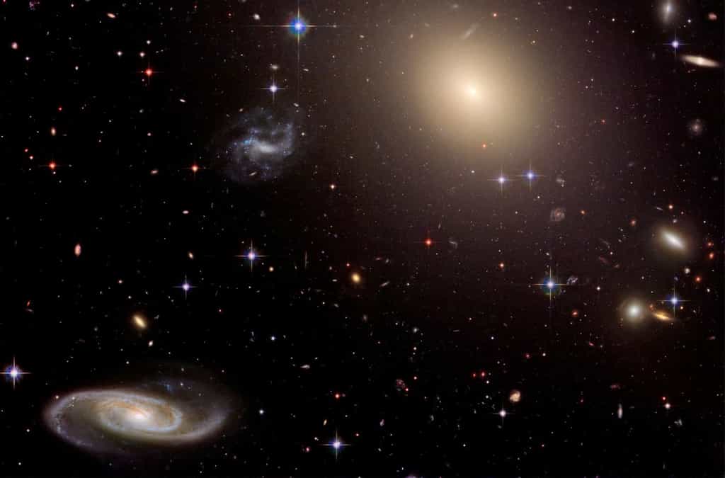 Une collection de galaxies au sein de l’amas Abell S0740, à plus de 450 millions d’années-lumière de la Terre, vue par Hubble. Occupant le centre de l’amas, la géante elliptique ESO 325-G004 est entourée de milliers d’amas globulaires, chacun composé de centaines de milliers d’étoiles liées entre elles par la gravité. Cette image a été construite avec des observations de 2005 et de 2006. © Nasa,&nbsp;ESA, and The Hubble Heritage Team (STScI/AURA)