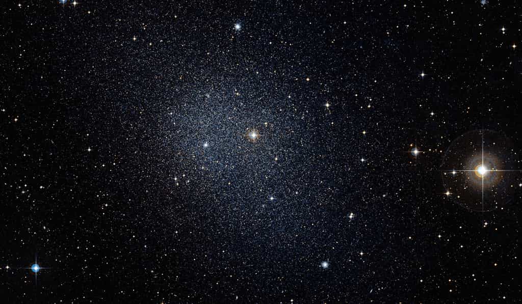 Distante d’environ 450.000 années-lumière, la galaxie du Fourneau est une des galaxies naines capturées par les forces gravitationnelles de la Voie lactée. Son destin est de se fondre dans notre grande communauté galactique. © Eso, DSS2