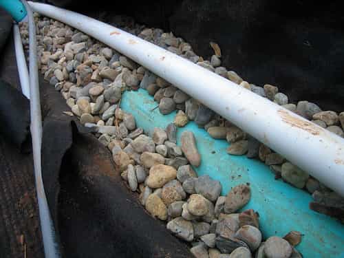 En construction, le tuyau de drain permet l'évacuation du surplus d'eau au pied des bâtiments. © Jeff Tidwell, CC BY 2.0, Flickr