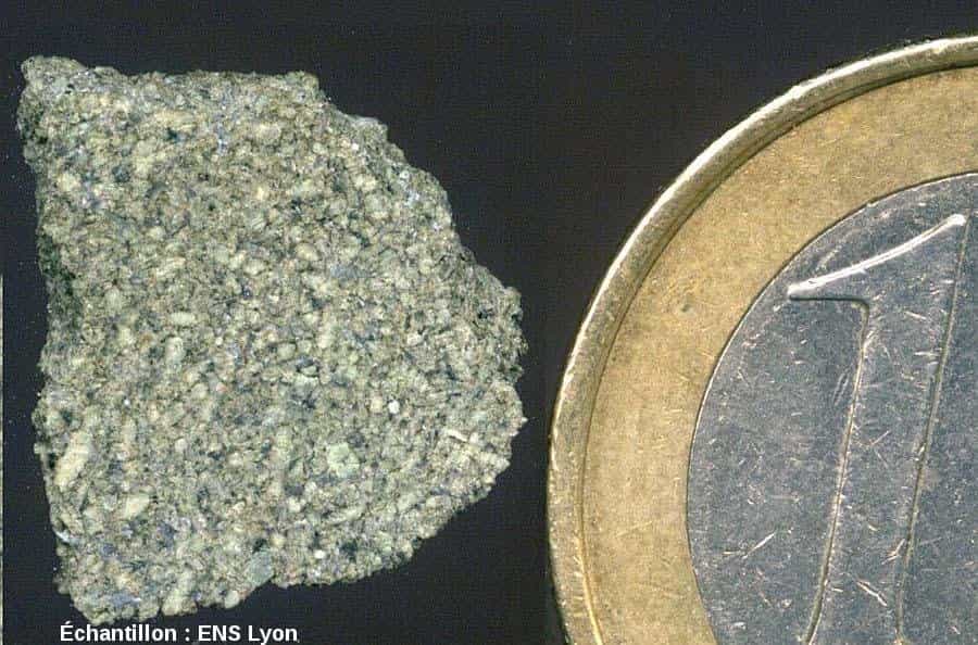 Cet échantillon martien mesure 1,3 cm dans sa plus grande dimension. Les cristaux clairs sont des pyroxènes. Leur pauvreté en fer explique leur couleur très claire. Ils ont une dimension moyenne de 0,4 mm. Les zones très sombres correspondent aux maskelynites (feldpaths amorphisés). Il s'agit donc d'un gabbro à pyroxènes clairs et à feldspaths sombres, ce qui n'est pas banal. © Pierre Thomas, ENS Lyon