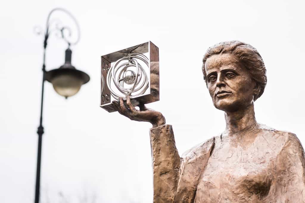 Le polonium a été découvert par Pierre et Marie Curie. Cette dernière est représentée ici tenant une représentation du polonium ; la statue, du sculpteur Bronislaw Krzysztof, se situe à Warsow, en Pologne. © Huang Zheng, Shutterstock