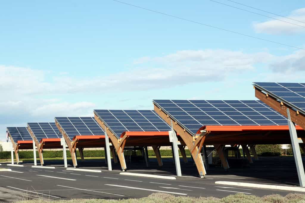 Sur une aire de parking, une ombrière photovoltaïque offre l'avantage&nbsp;de production d'énergie verte tout en protégeant les véhicules y stationnant.&nbsp;© illustrez-vous, Adobe Stock