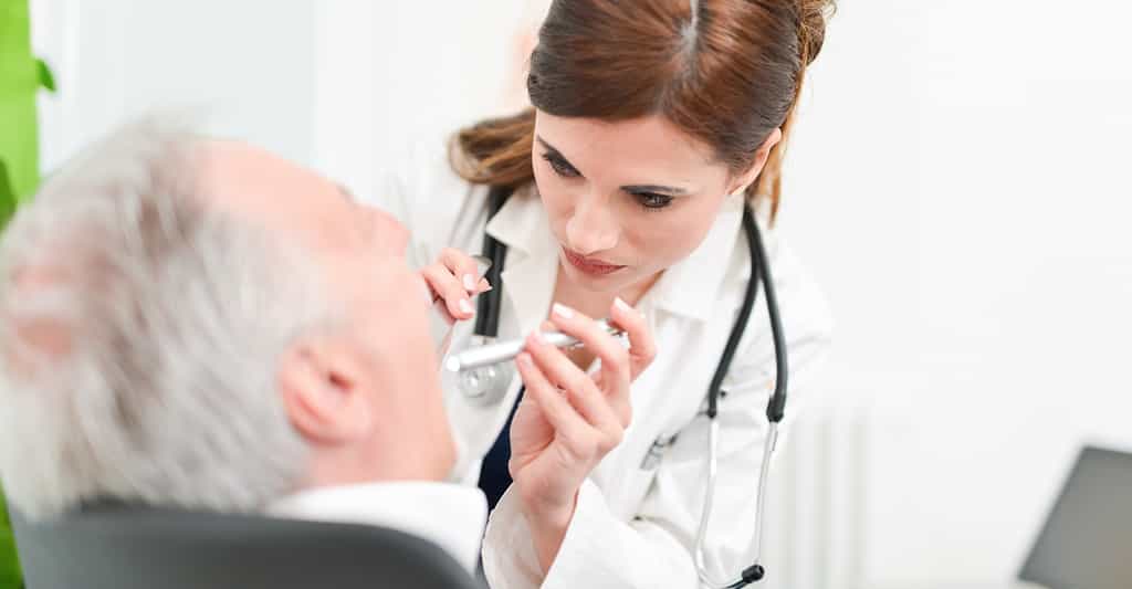 Le médecin examine la langue dans le cadre du diagnostic du cancer de la langue. © Minerva Studio, Shutterstock