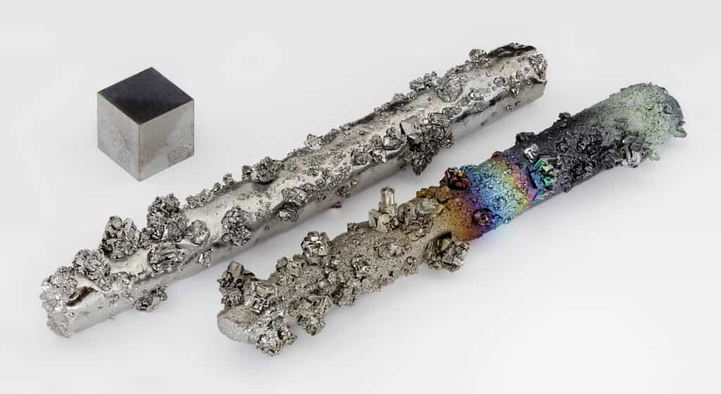 Le tungstène est l'élément chimique ayant le plus haut point de fusion (3.422 °C). Ici deux barres de tungstène avec des cristaux évaporés, partiellement oxydés (la couleur sur la barre de droite est un phénomène d'optique provoqué par une mince couche d'oxyde), d'une pureté de 99,98 %. À gauche, un cube de 1 cm³ de tungstène pur (99,999 %). © Alchemist-hp, Wikimedia Commons, CC by-nc-nd 3.0