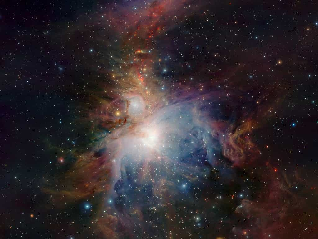 Cette vue à grand champ de la nébuleuse d’Orion (Messier 42), située à environ 1 350 années-lumière de la Terre, a été prise avec le télescope infrarouge VISTA de l’observatoire Paranal de l’ESO au Chili. Le champ de vision immense du nouveau télescope permet d’obtenir une image unique de la nébuleuse et de ses environs. Sa vision infrarouge lui permet également de scruter en profondeur les régions poussiéreuses normalement cachées et de révéler les étranges activités des jeunes étoiles très actives qui y sont enfouies. Cette image a été créée à partir d’images prises à travers des filtres Z, J et Ks dans la partie proche infrarouge du spectre. Les temps d’exposition étaient de dix minutes par filtre. L’image couvre une région du ciel d’environ un degré sur 1,5 degré. © ESO, J. Emerson, Vista